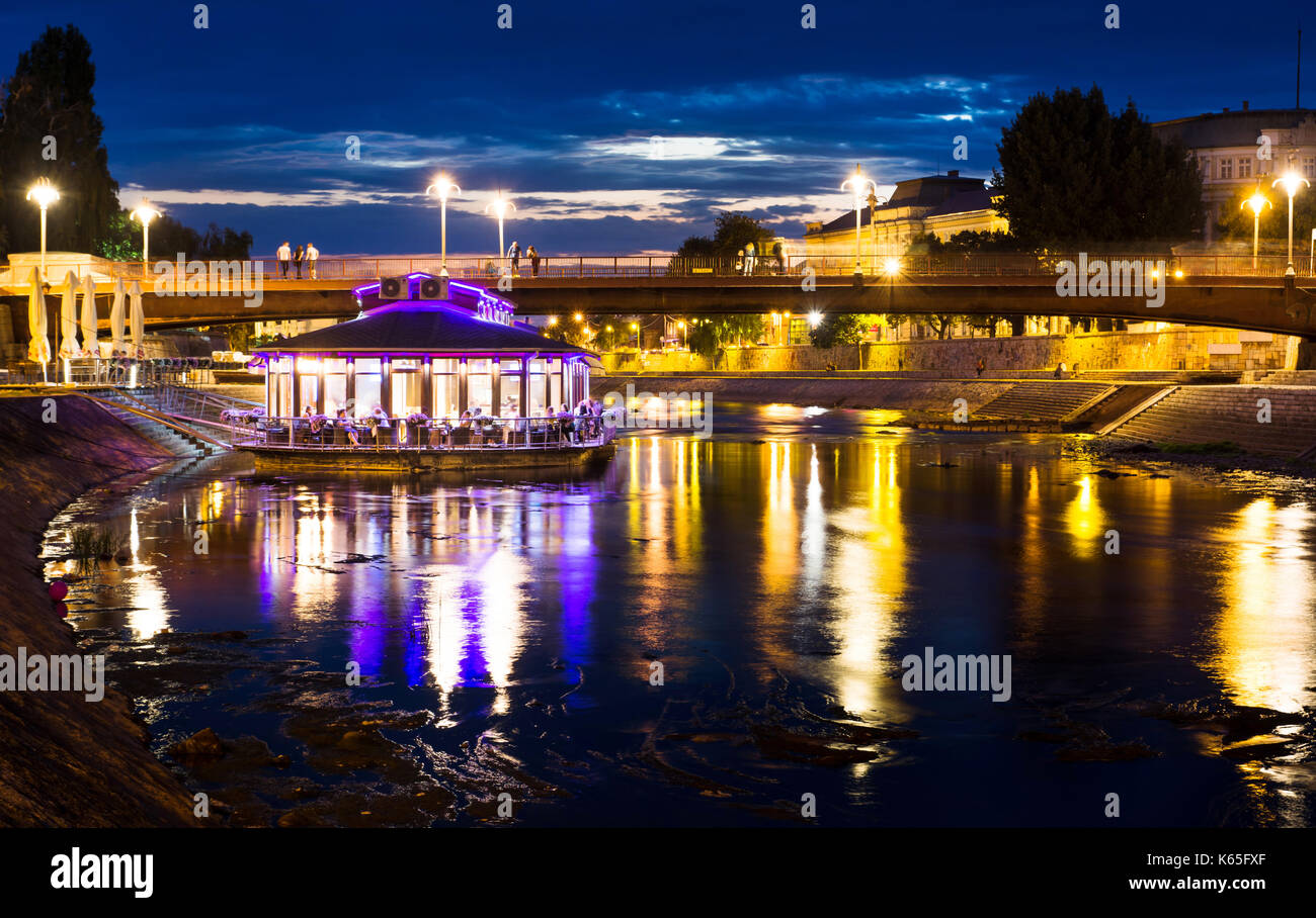 Nis, Serbia - 8 settembre 2017: nisava fiume con floating coffee bar in acqua nella parte anteriore del ponte e palazzo universitario. nis è il terzo l Foto Stock