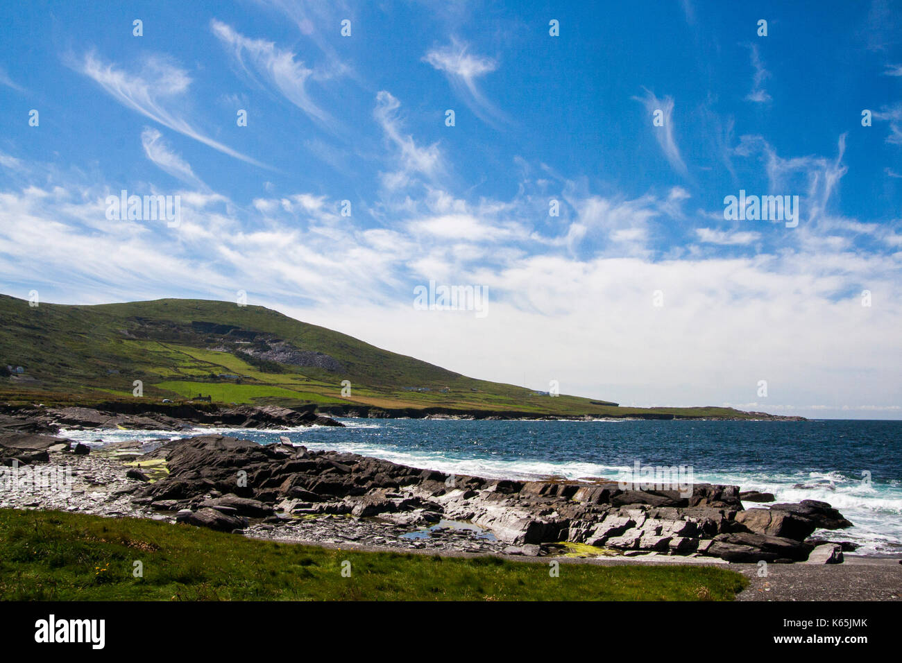 Paesaggio di colpo la linea costiera a Cromwell punto,Valentia Island, Ring of Kerry, Irlanda su un luminoso giorno contro un cielo blu con nuvole cirrus Foto Stock
