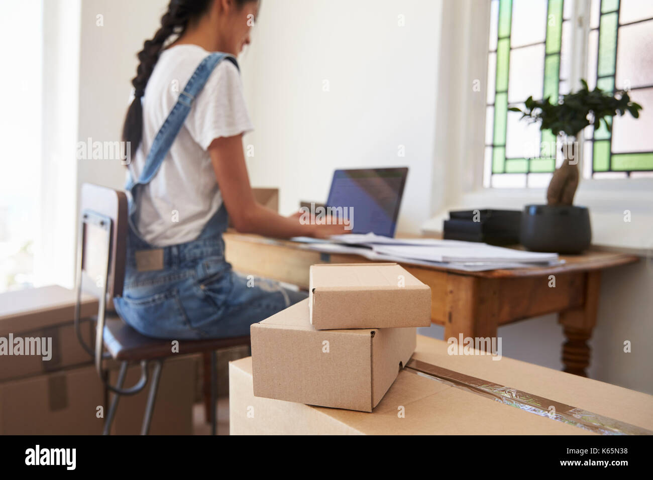 Vista posteriore della donna in esecuzione dal Business Home spedire delle merci Foto Stock