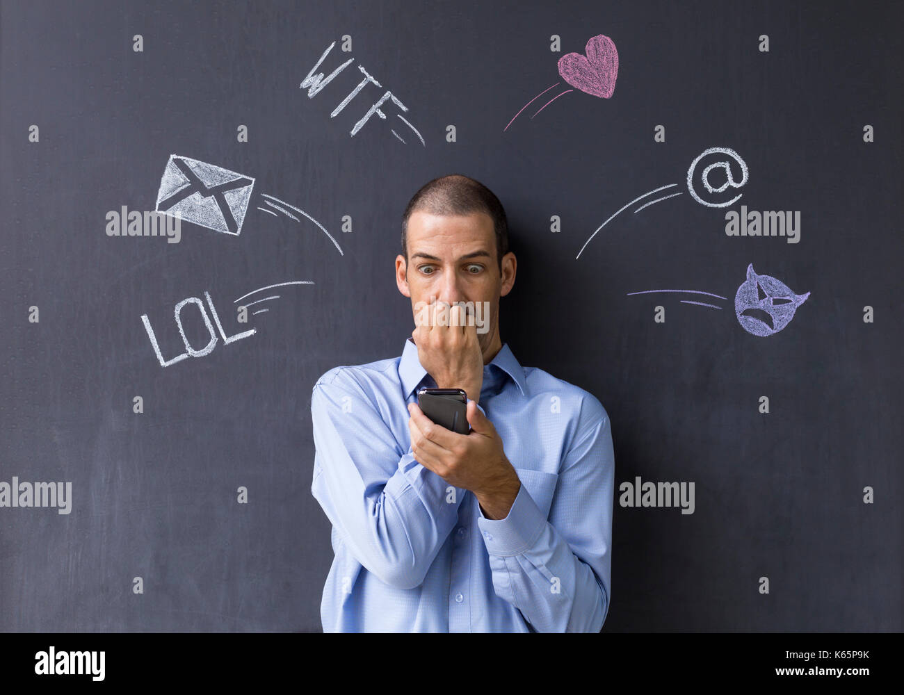 Concetto di social media chat. Singola bianco uomo adulto in piedi di fronte a una lavagna usando il suo smart phone. Foto Stock