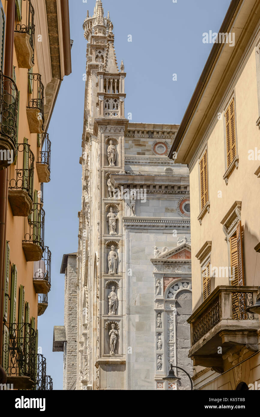 Paesaggio con dettaglio di statue sul bordo della cattedrale gotica, girato in condizioni di intensa luce estiva a como, lombardia, italia Foto Stock