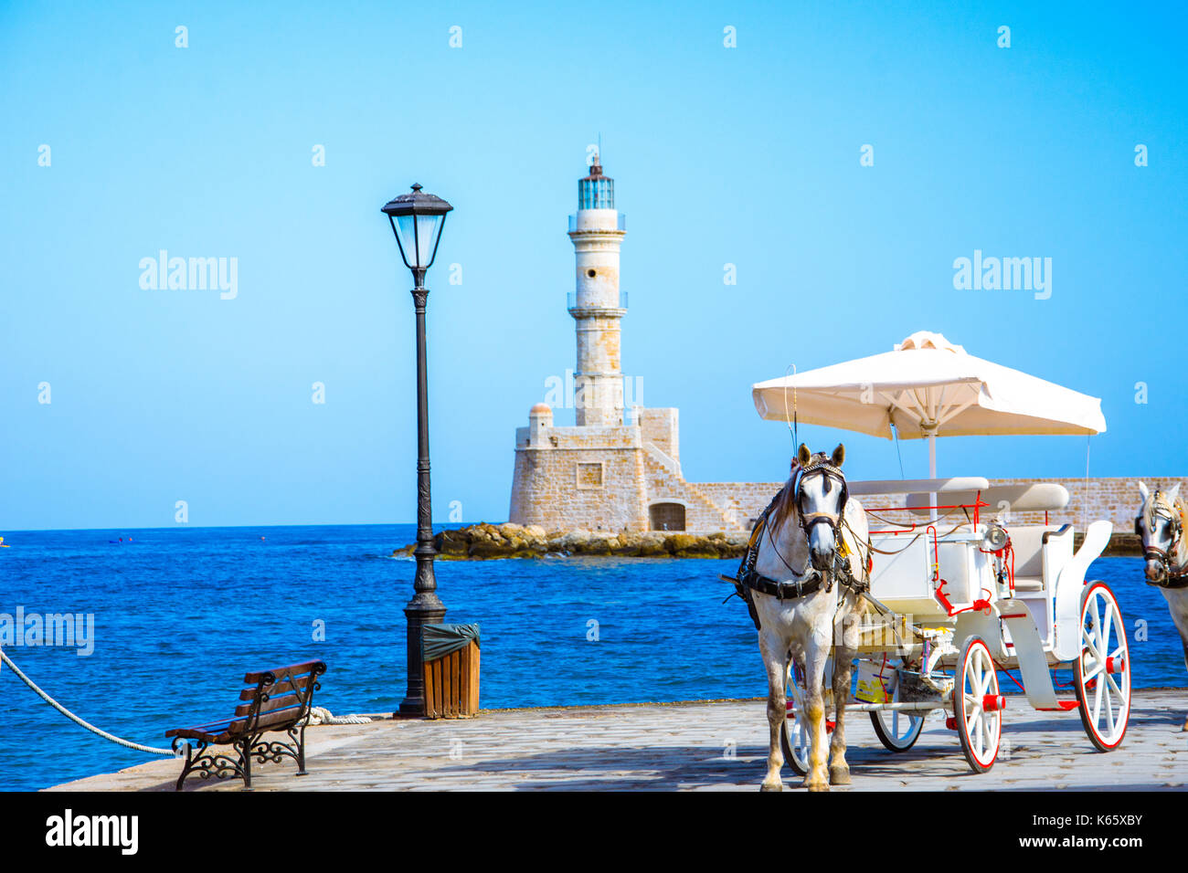 Vista del porto vecchio di Chania con carrozze e il faro, Creta, Grecia. Foto Stock
