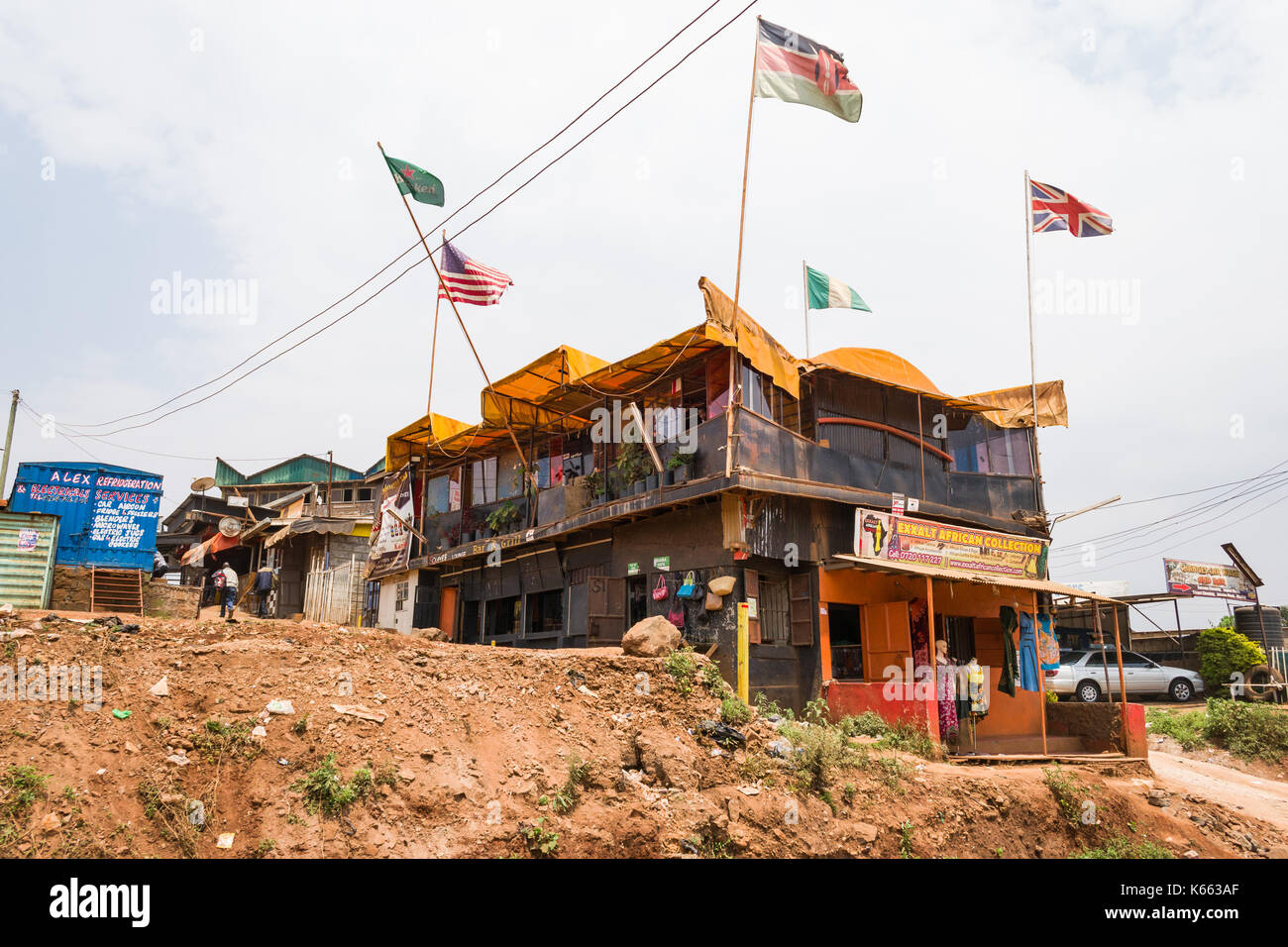 Edificio con vari negozi di paese con le bandiere sventolano dal tetto, Kenya Foto Stock