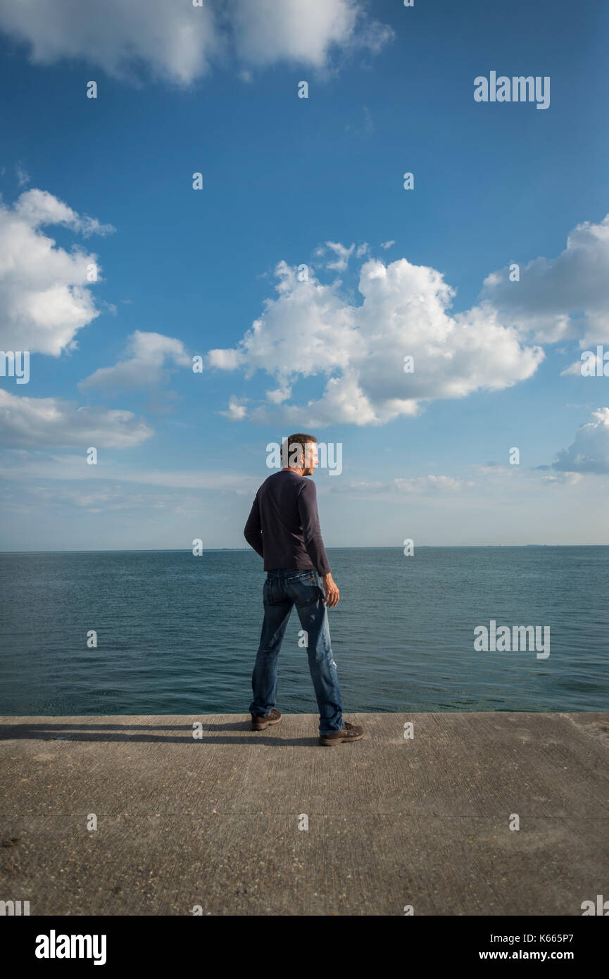 Uomo che guarda al mare Foto Stock