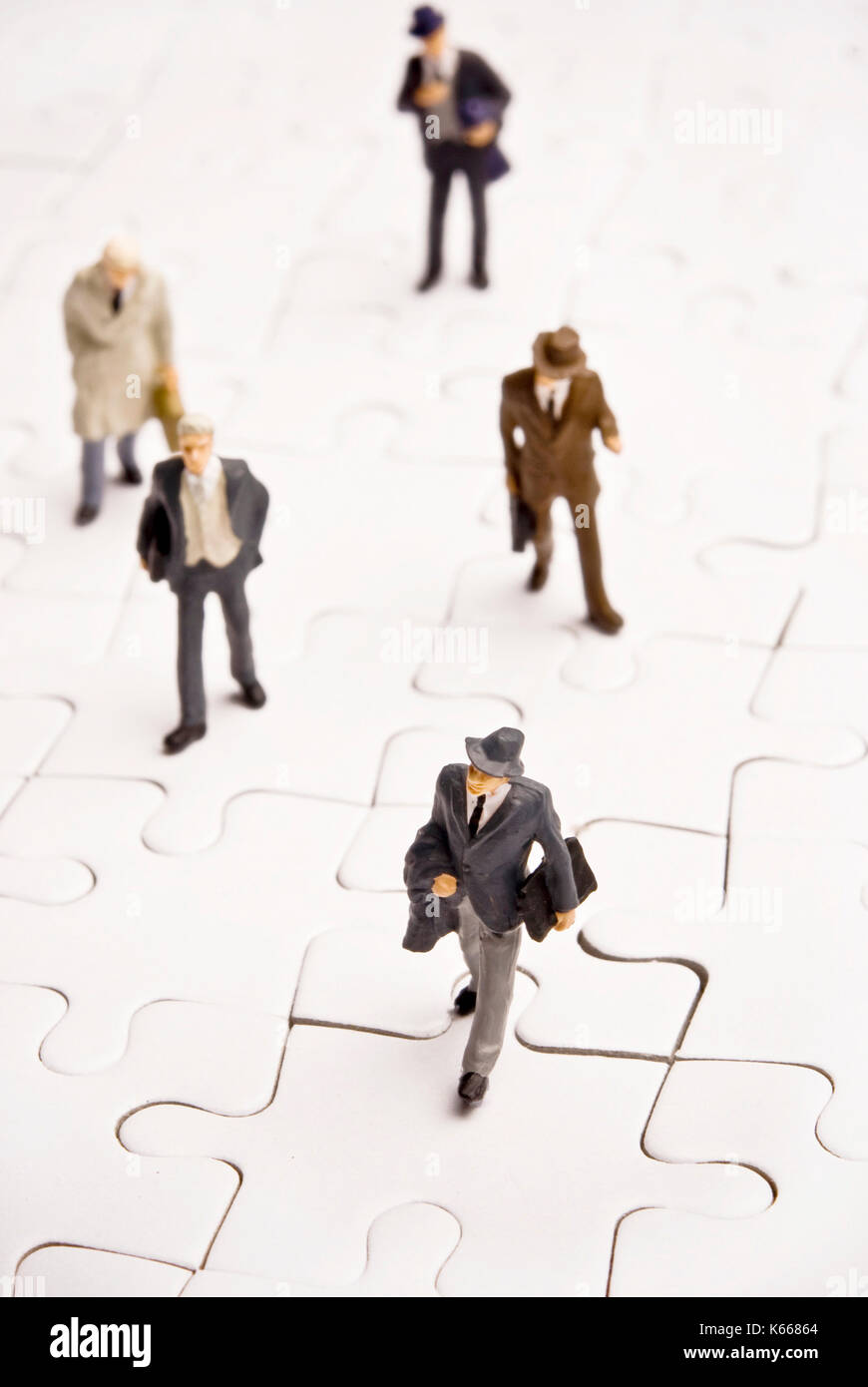 Business figurine in miniatura su puzzle Foto Stock