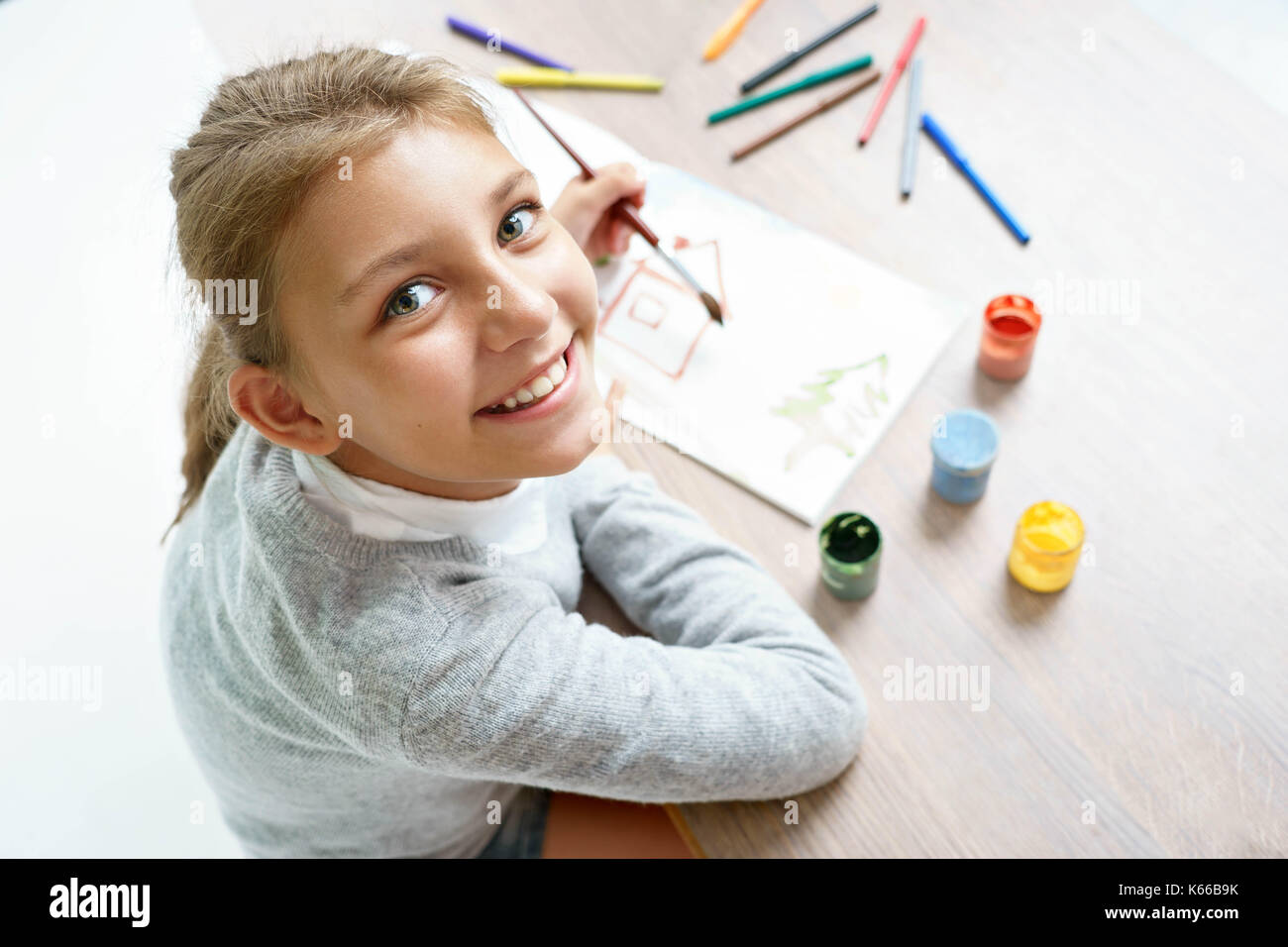 Sorridenti schoolgirl è il disegno. La foto di un simpatico bambina studiare. Il concetto di istruzione Foto Stock