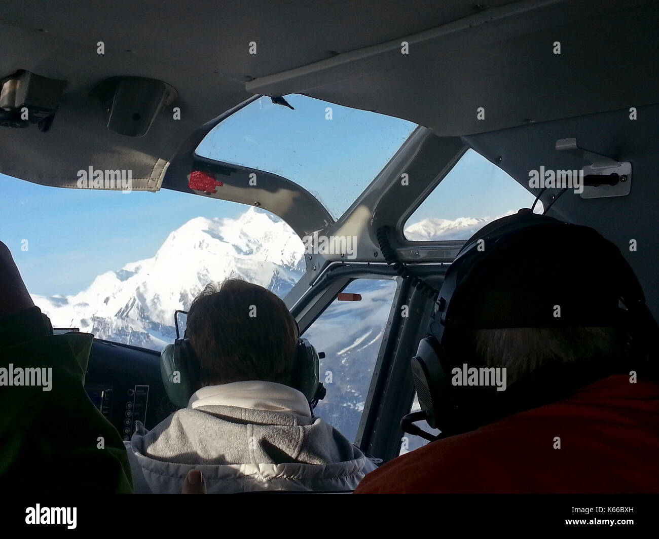 Interior shot di touring aereo con vista delle montagne innevate al di fuori di finestra, Alaska Foto Stock