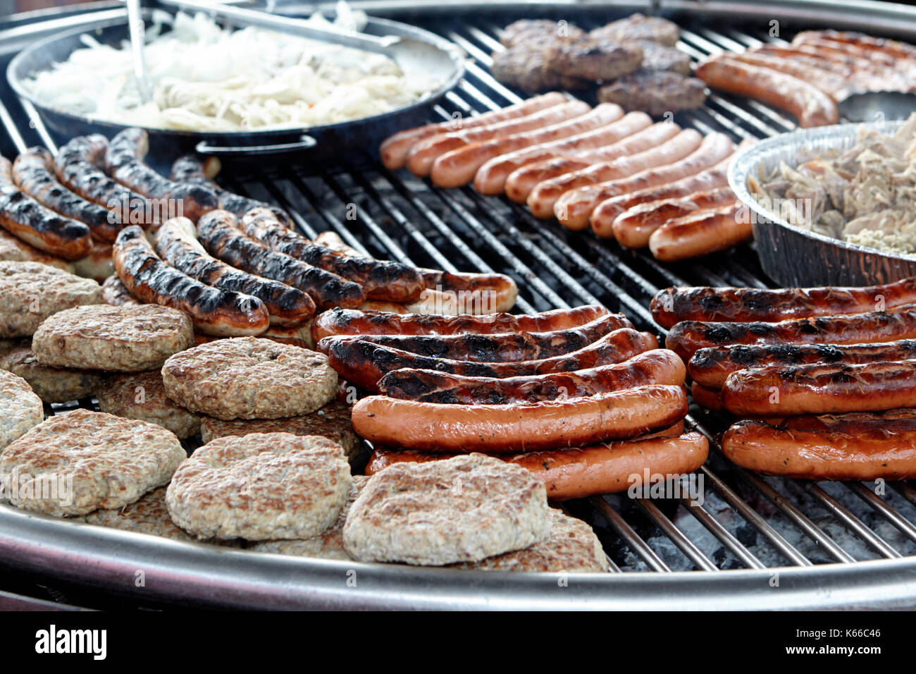 Salsicce e hamburger su un tedesco schwenkgrill Foto Stock