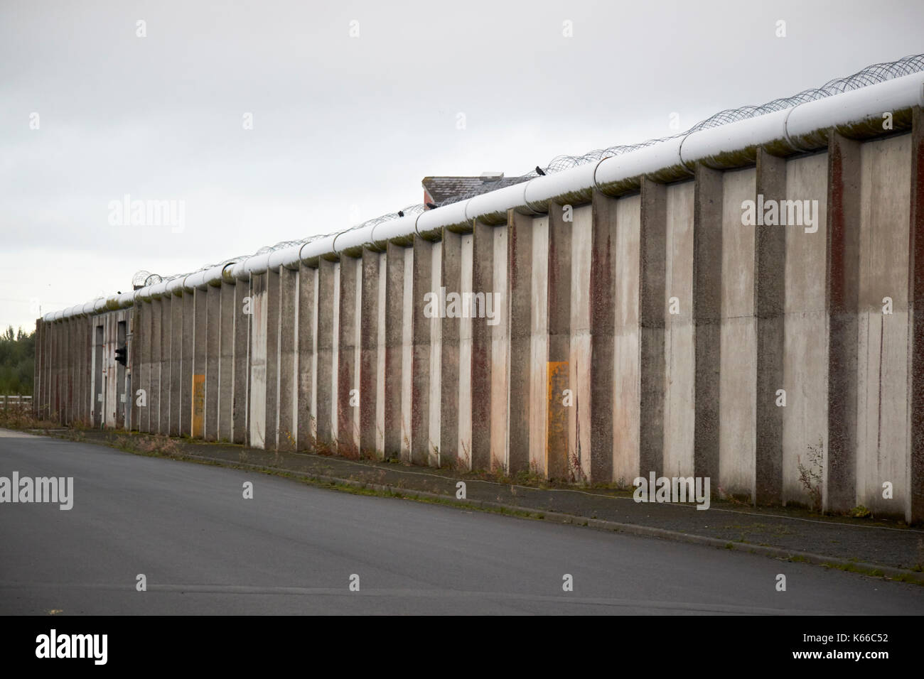 Strada di accesso e filo spinato e rabboccato pareti interne di uno dei blocchi di h nella ex prigione labirinto long kesh sito Irlanda del Nord Foto Stock