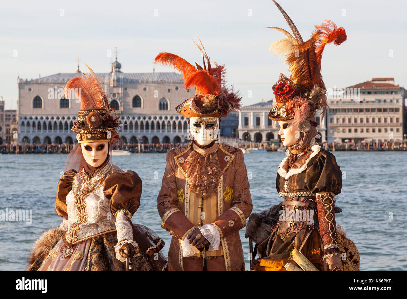 2017 Il Carnevale di Venezia. Tre persone in classico revival costumi pongono a San Girgio Maggiore con il Palazzo dei Dogi e la laguna dietro di loro a s Foto Stock