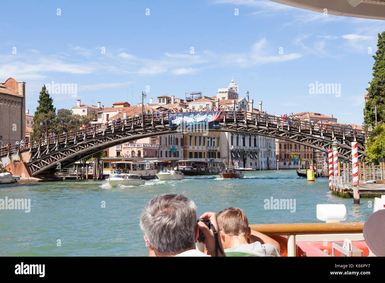 I turisti su un vaporetto che viaggiano fino al Grand Canal, Venezia, Italia da una prima persona il punto di vista a bordo di guardare oltre la prua all'Accademia B Foto Stock