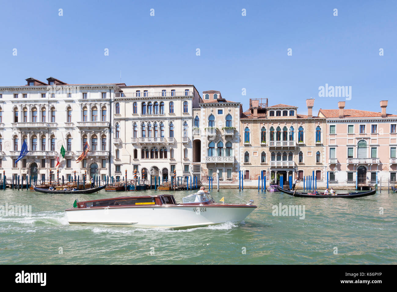 Acqua taxi e gondole sul Grand Canal, Venezia, Veneto, Italia passando davanti a palazzi storici, su una soleggiata giornata estiva Foto Stock