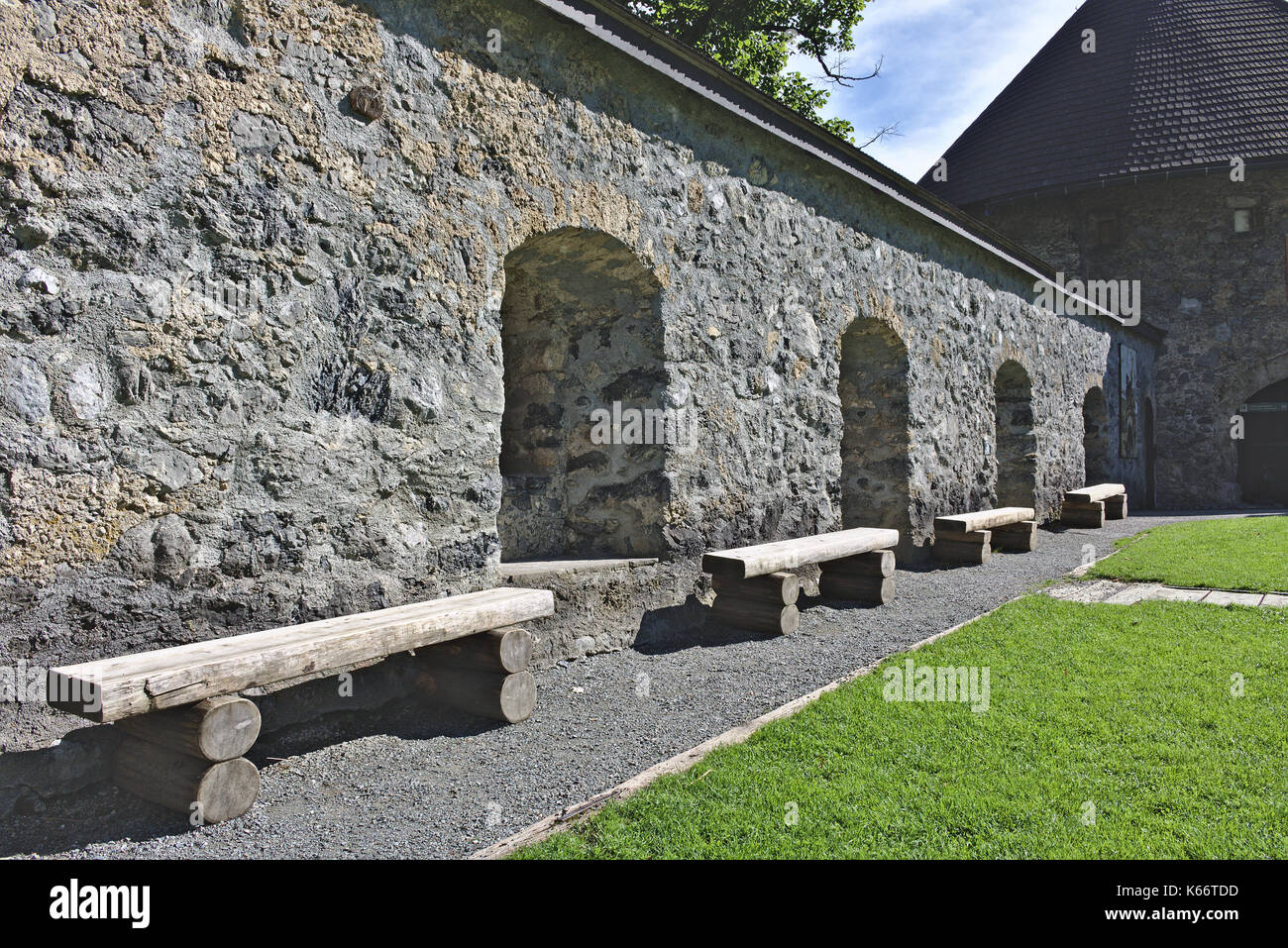 Vista interna del soleggiato parete del medievale castello hohenwerfen, Austria con alcove ombreggiata e ruvide panche di legno Foto Stock