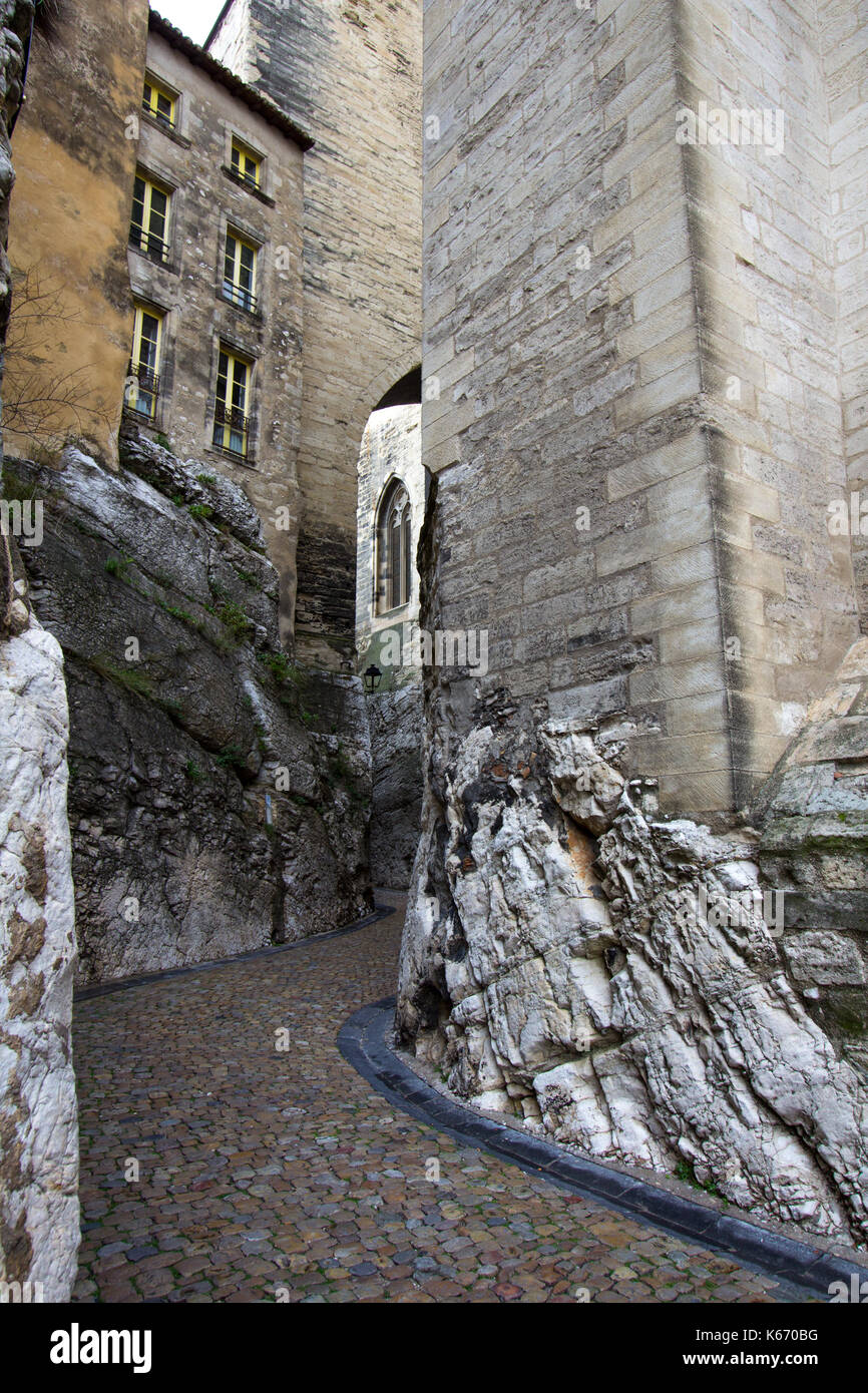Curvatura stretta viuzza tra alti edifici in avignon, Francia Foto Stock
