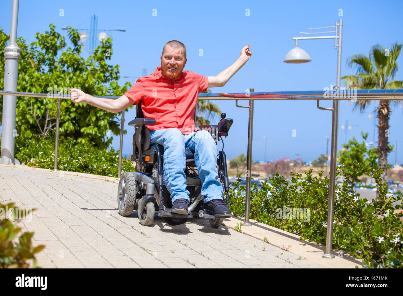 Uomo disabili su sedia elettrica godere al parco Foto Stock