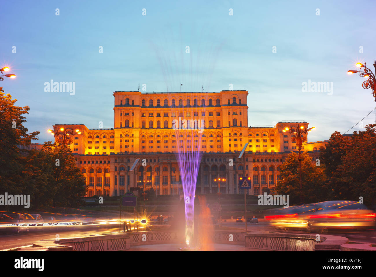 Liberty boulevard al crepuscolo con fontane illuminate guardando verso il palazzo del parlamento, il più amato e più odiato edificio in Romania. Foto Stock