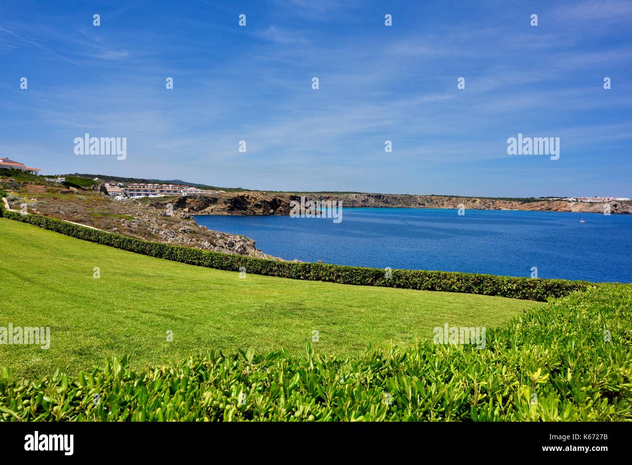 Un curato prato con un mare blu visualizza Arenal den Castell Menorca Minorca spagna Foto Stock