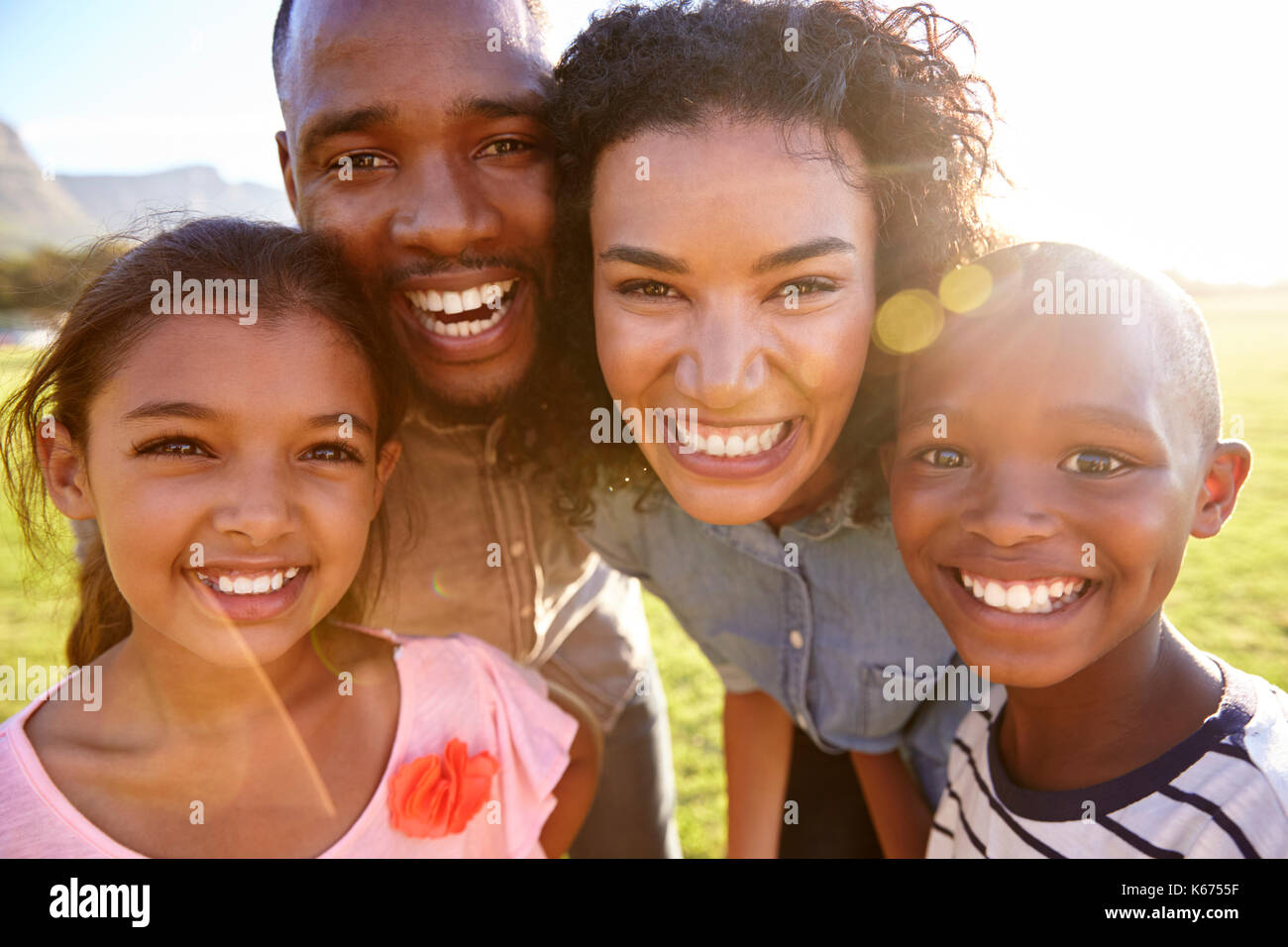 Ridendo famiglia nero all'aperto, vicino, back lit ritratto Foto Stock