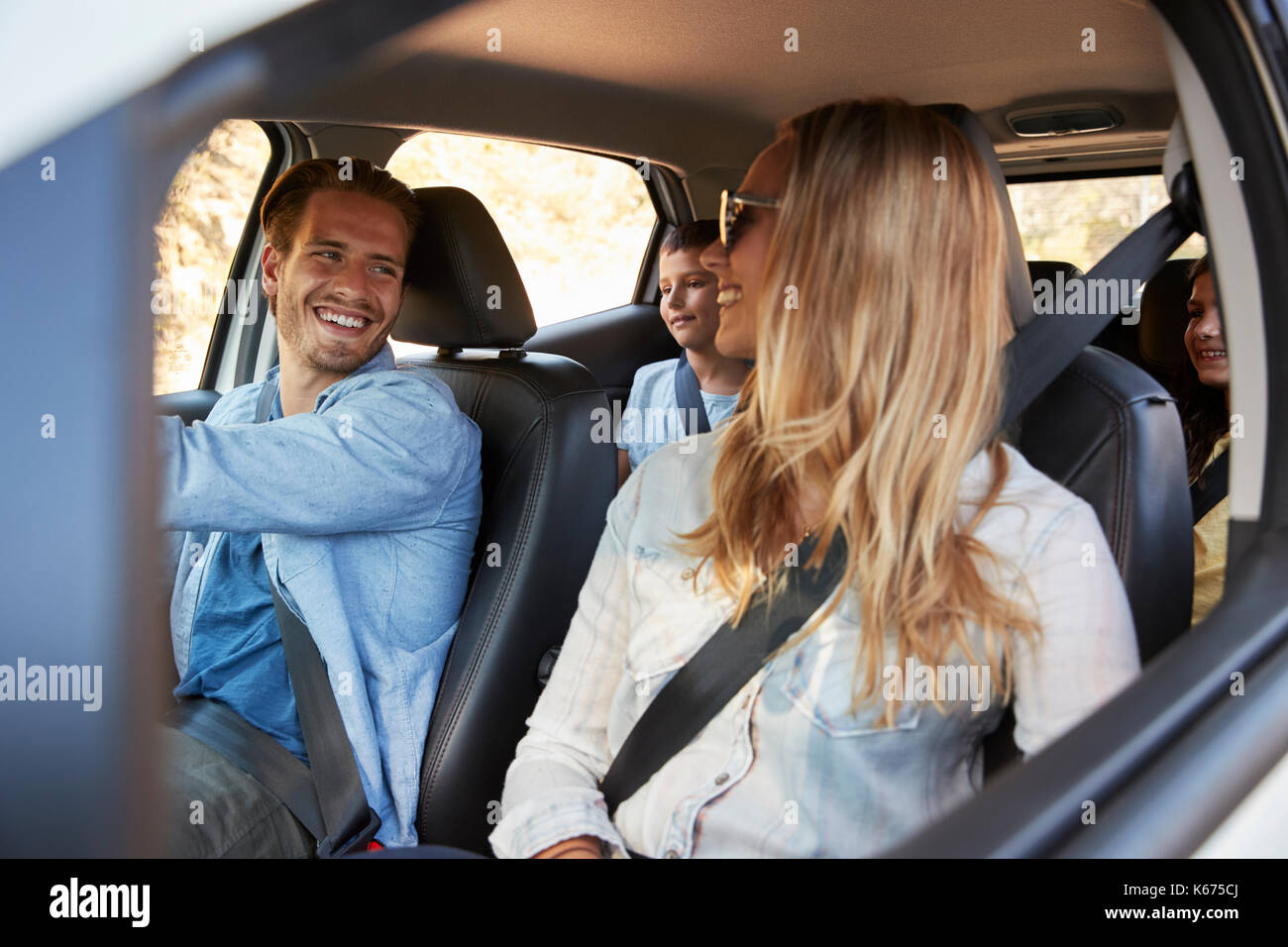 Giovane famiglia con due bambini di andare in vacanza in auto Foto Stock