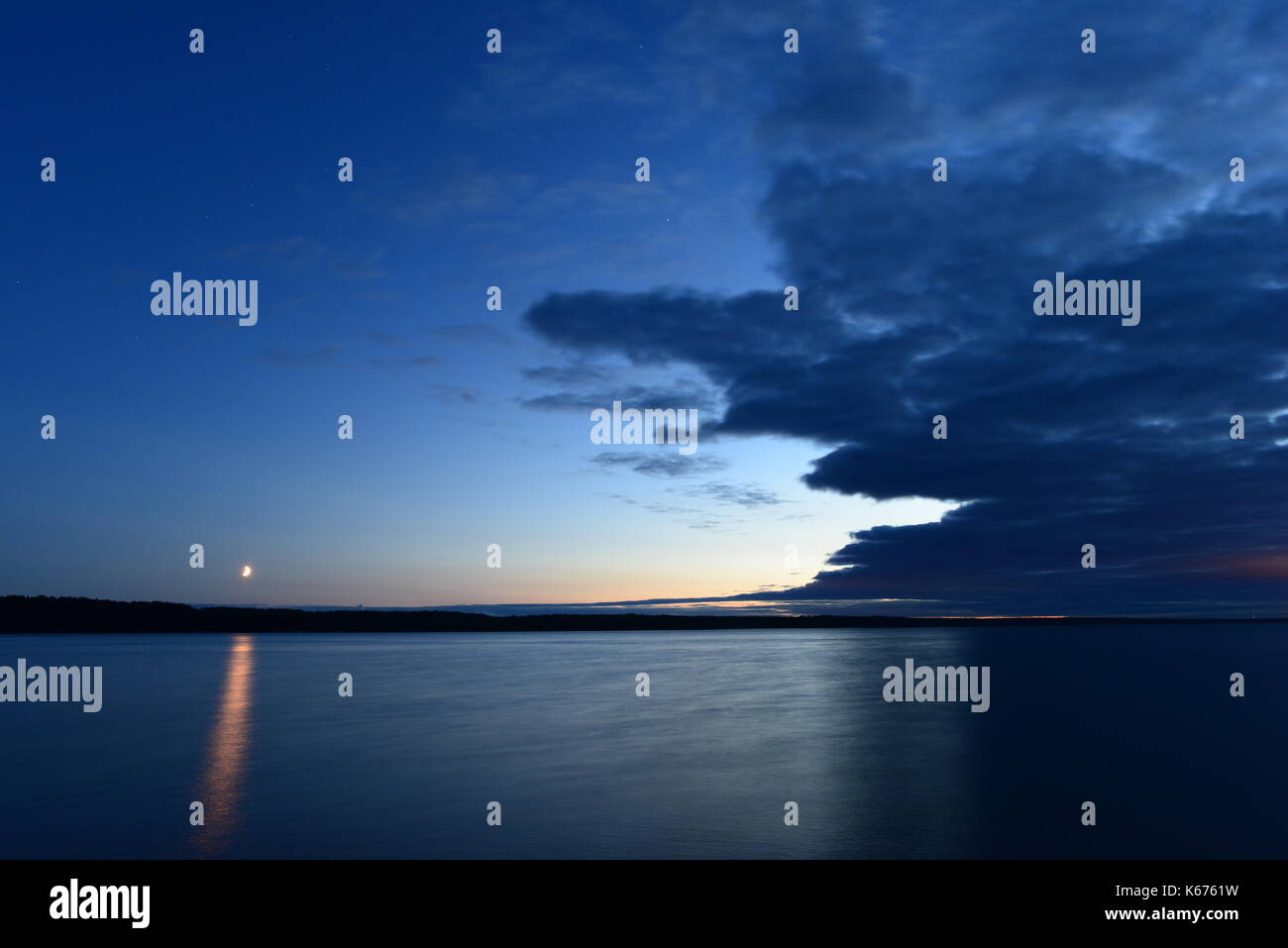 Cielo stellato di notte al chiaro di luna sulla superficie delle acque del lago Foto Stock