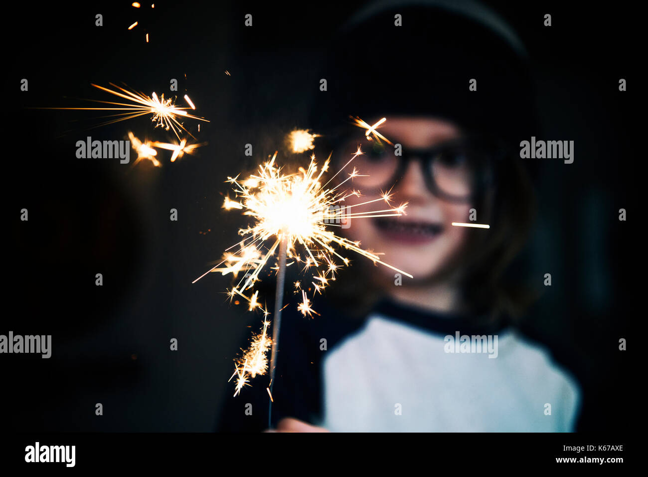 Ritratto di un ragazzo sorridente tenendo un sparkler Foto Stock