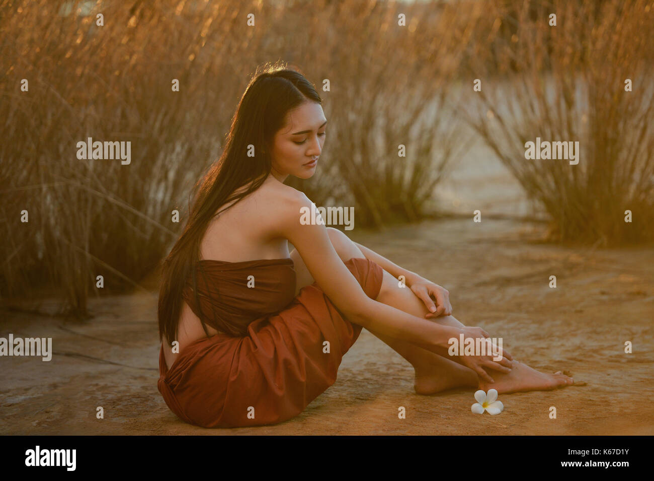 Bella donna seduta sulla spiaggia, Thailandia Foto Stock