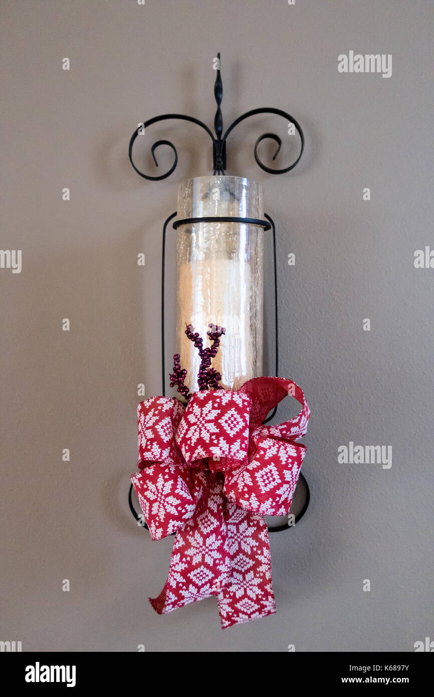 Una candela bianca in ferro battuto titolare e red ribbon festosa. Foto Stock