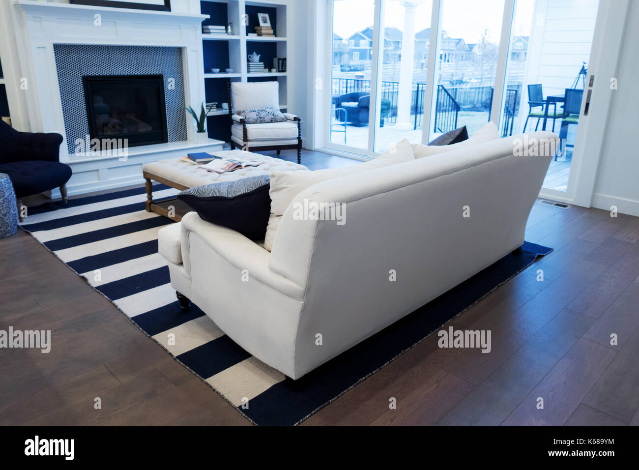Un lettino di bianco in un salotto che si affaccia sul patio esterno. Foto Stock