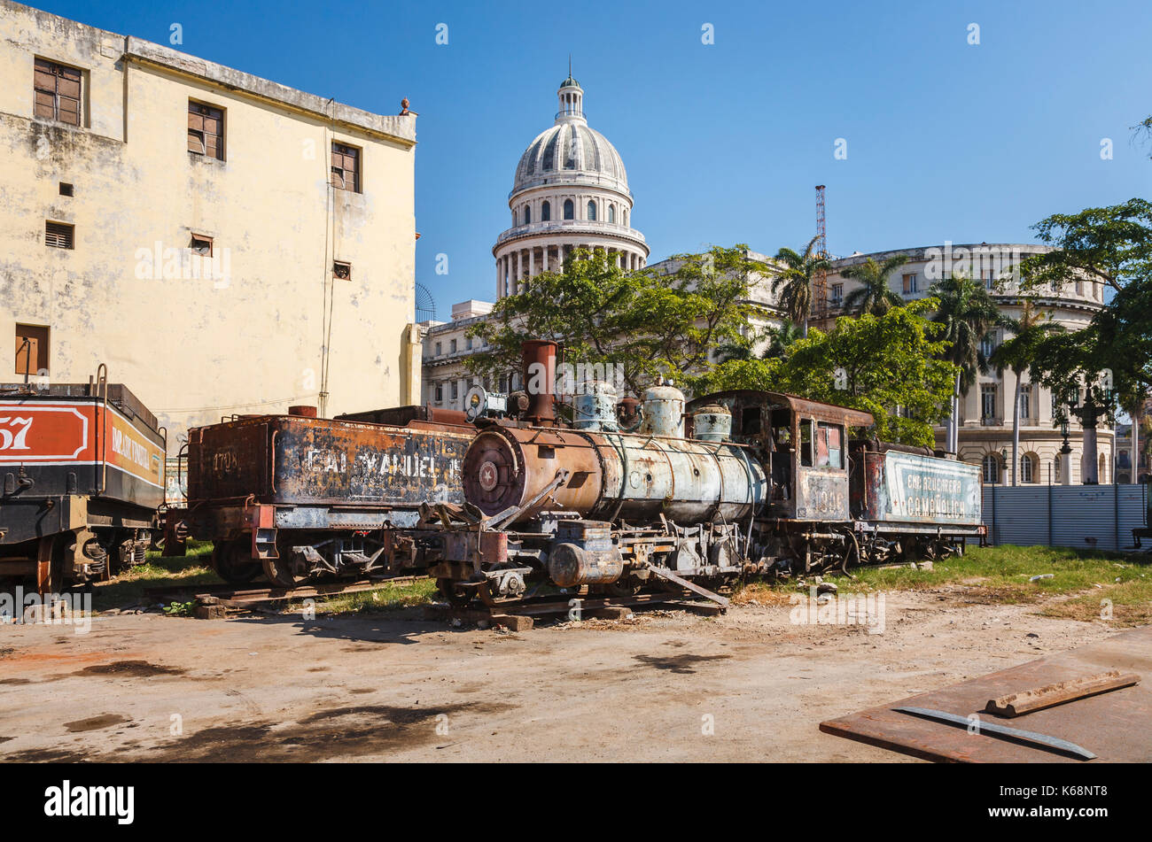 Scrapyard dietro la mitica capitale nazionale edificio nel centro di Avana, capitale di Cuba, con derelitti, arrugginimento locomotore ferroviario motori Foto Stock