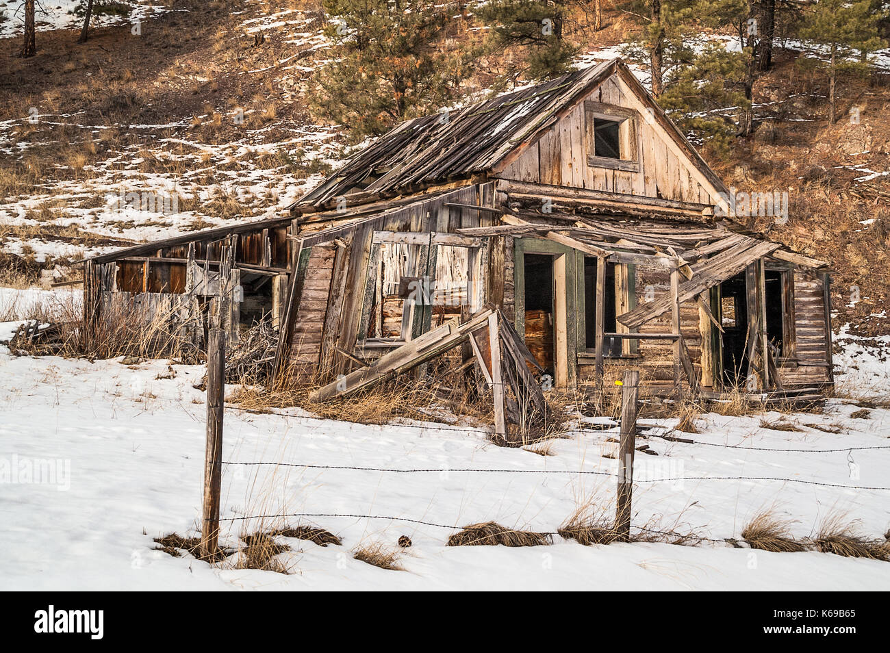 Casa diroccata che mostra anni di abbandono nel sole di sera Foto Stock
