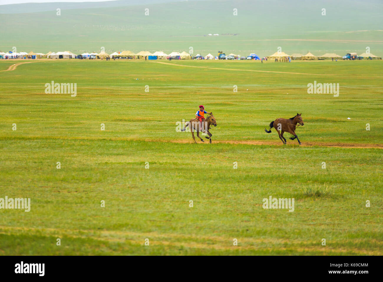 Ulaanbaatar, in Mongolia - giugno 12, 2007: giovane ragazzo a cavallo che portano il pacco all'Horse Racing evento concorso del festival di naadam Foto Stock