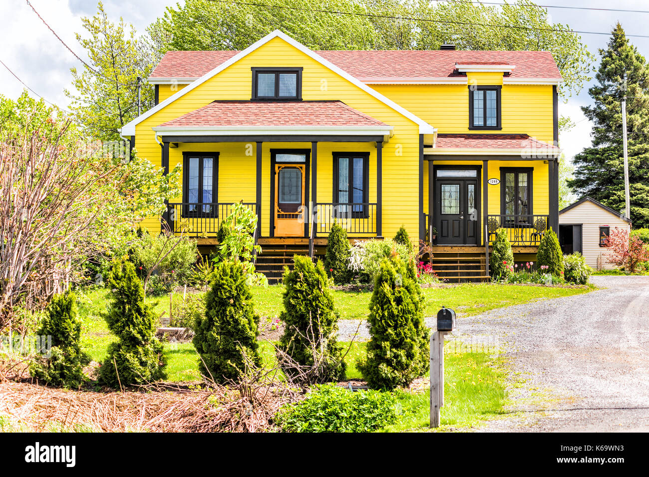 Ile D'Orleans, Canada - 1 Giugno 2017: dipinte di un giallo, rurale rustico con road, cassetta postale nel paesaggio estivo campagna francese durante la stagione estiva Foto Stock