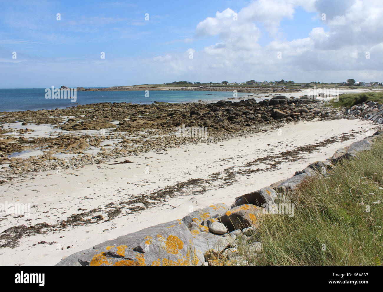 Vista sul litorale roccioso e la bella spiaggia di sabbia dorata a la Greve Blanche, vicino Plouguerneau a Britttany in Francia. Foto Stock