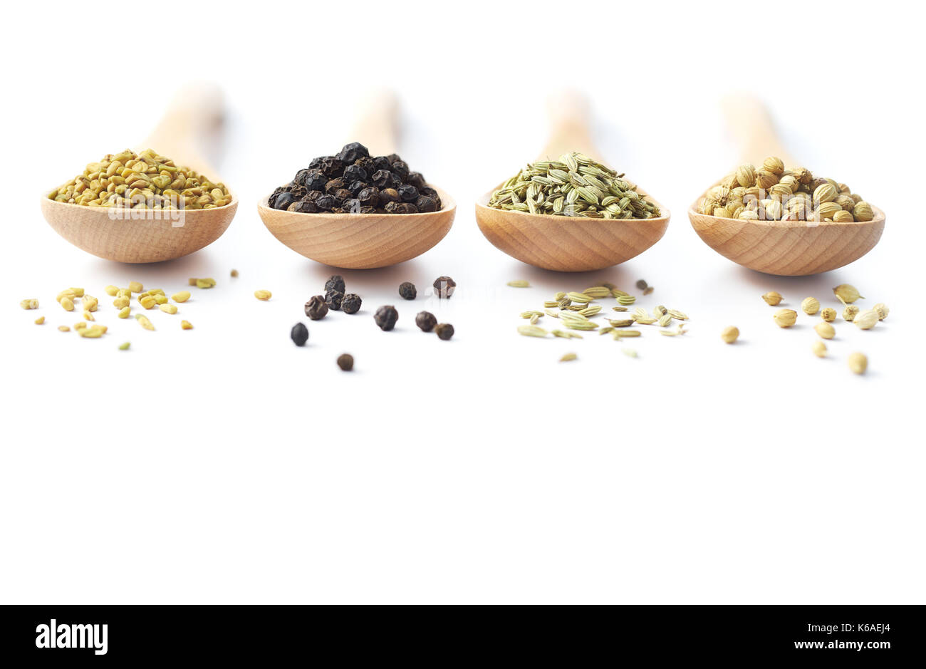 Cucchiaio di legno riempita con spezie - fieno greco, Peppe nero, Finocchio e coriandolo Foto Stock