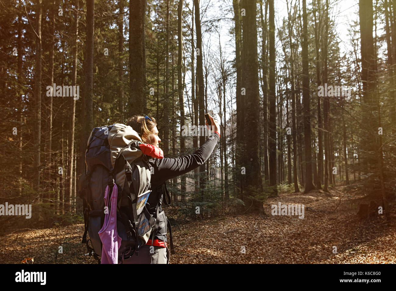 Donna prendendo un selfie su una escursione attraverso i boschi. memoria raccolta, uno stile di vita attivo, il telefono cellulare e la rete sociale concetto di tossicodipendenza. Foto Stock