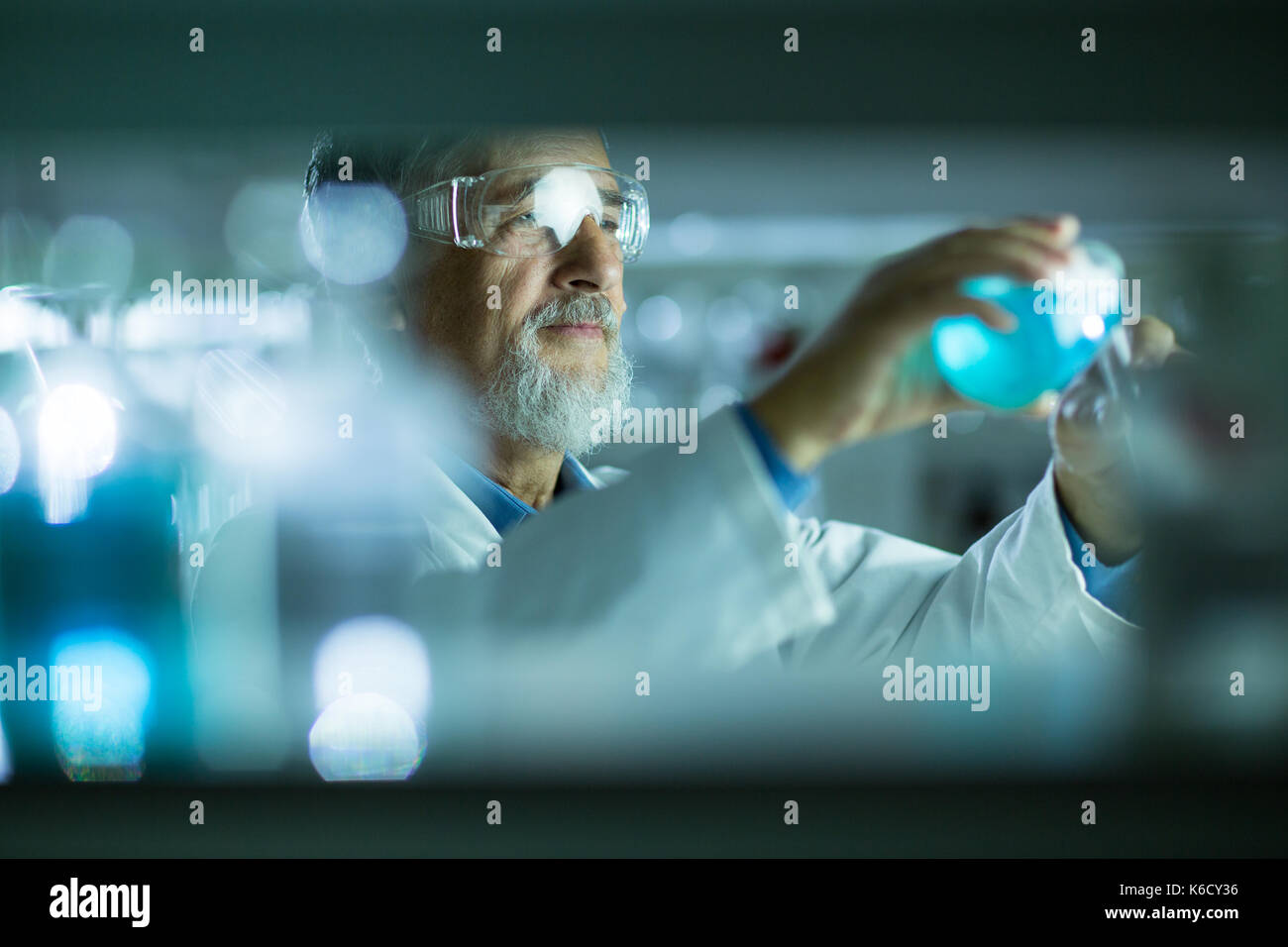 Maschio senior researcher di effettuare attività di ricerca scientifica in un laboratorio (shallow dof; dai toni di colore immagine) Foto Stock