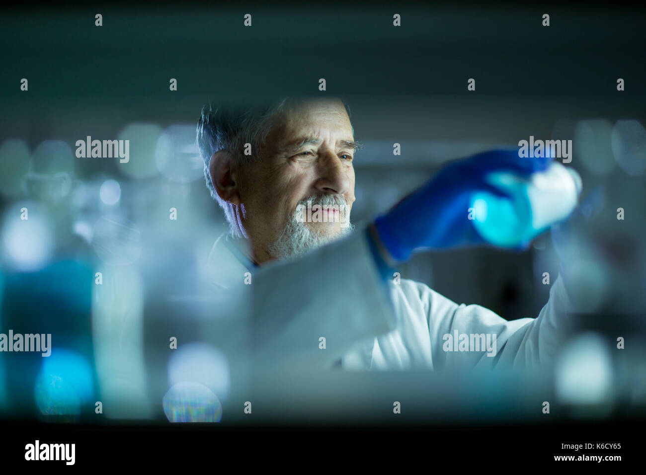 Maschio senior researcher di effettuare attività di ricerca scientifica in un laboratorio (shallow dof; dai toni di colore immagine) Foto Stock