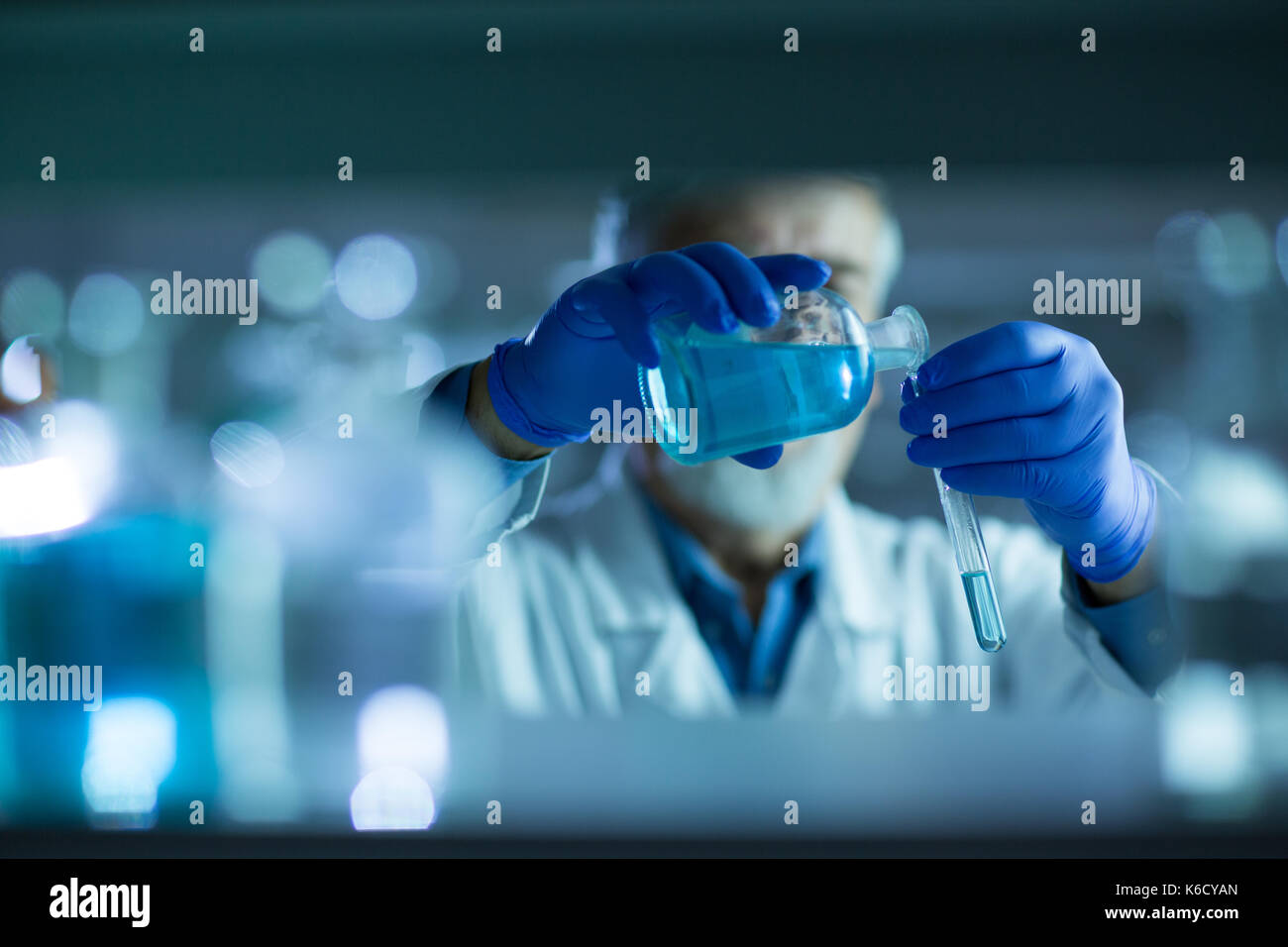 Maschio senior researcher di effettuare attività di ricerca scientifica in un laboratorio (shallow dof; dai toni di colore immagine) Foto Stock