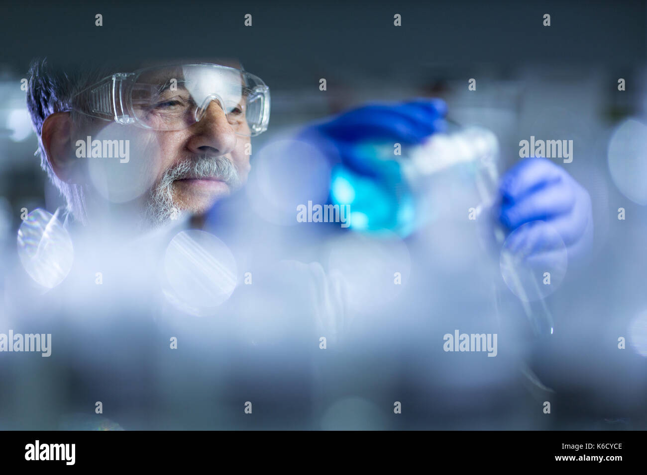 Maschio senior researcher di effettuare attività di ricerca scientifica in un laboratorio (shallow dof; dai toni di colore immagine) Foto Stock