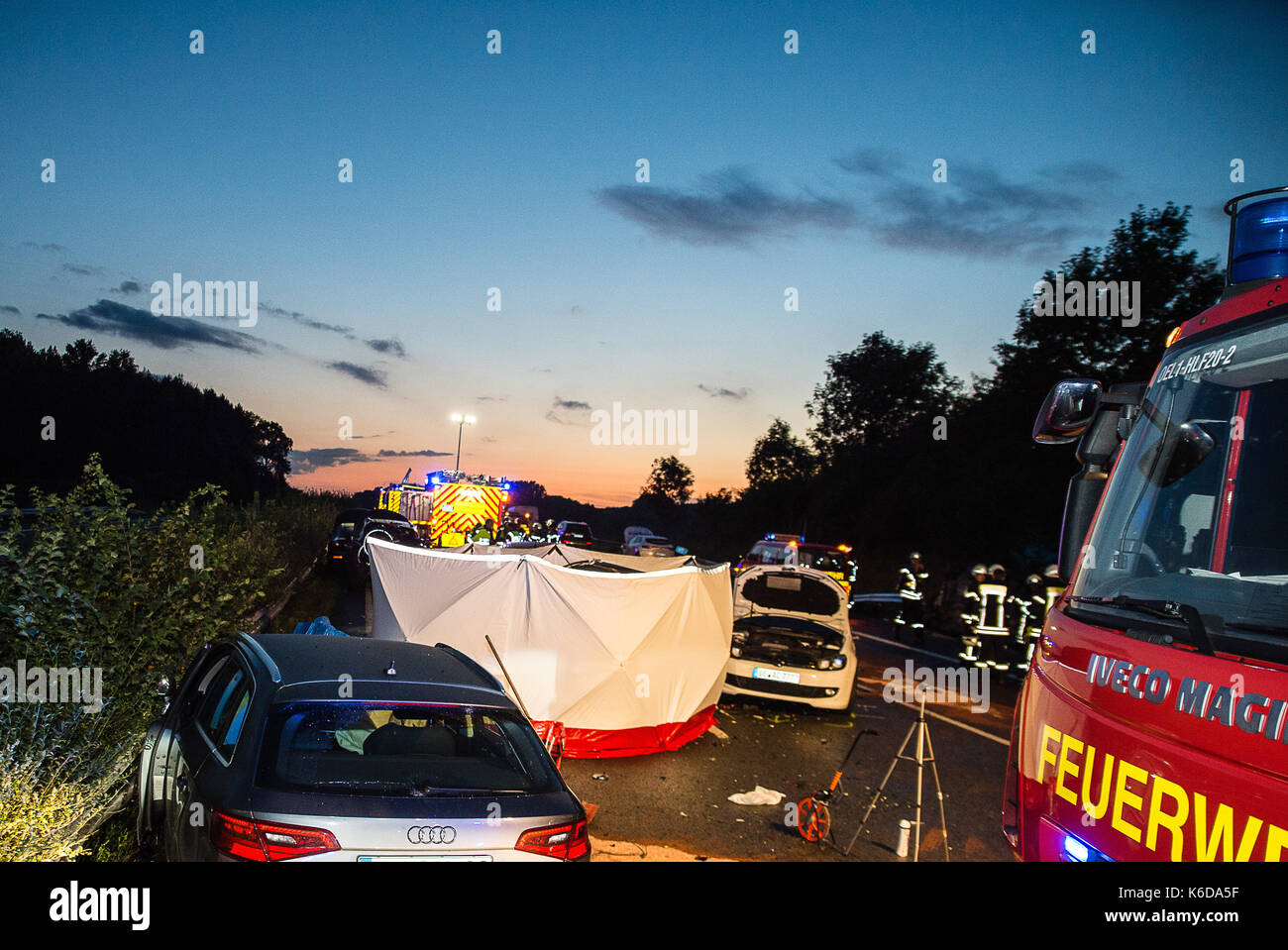 I vigili del fuoco sono accanto a un auto distrutte sull autostrada a2 vicino Oelde, Germania, 12 settembre 2017. durante una collisione sul autobahn 2 nella regione muensterland, due persone sono morte e almeno 17 feriti. diverse vetture, comprendente un bus, precipitava nel tardo pomeriggio, un portavoce della polizia in dortmund informato. photo: mathiesen-tv/dpa Foto Stock