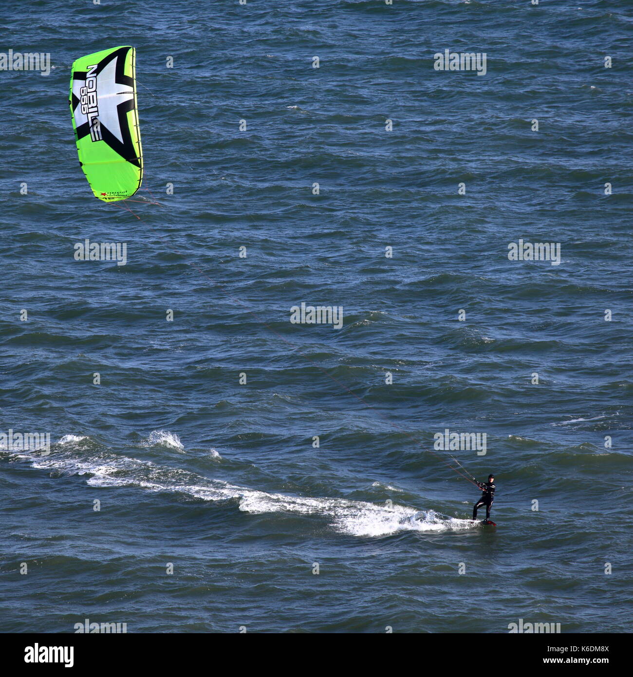 Elevato punto di vista di entrambi il kite e marinaio femmina / surfer godendo di buona velocità, branksome poole bay, Regno Unito Foto Stock