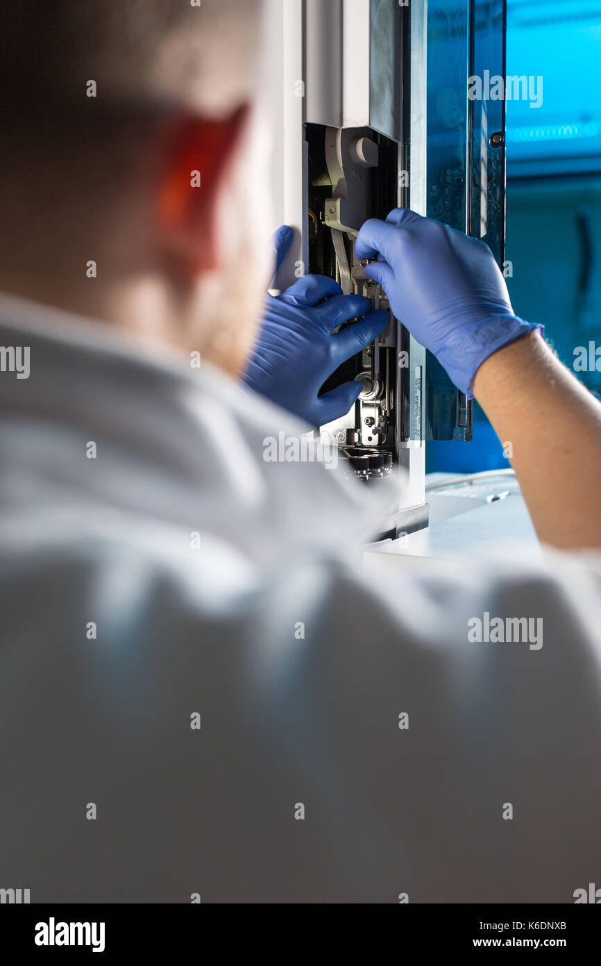Maschio senior researcher di effettuare attività di ricerca scientifica in un laboratorio (shallow dof; dai toni di colore immagine) Foto Stock
