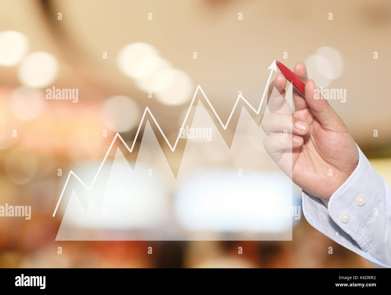 Imprenditore al punto di picco del grafico di business su abstract blur sullo sfondo,concetto simboli finanziari provenienti il successo e la redditività. Foto Stock