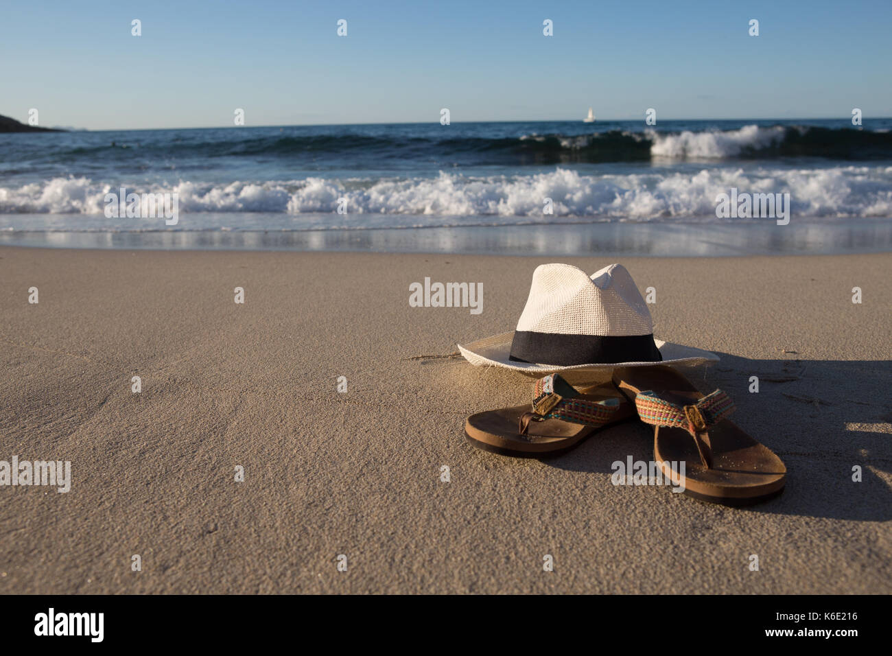 L'Europa, Spagna, Balearen, Mallorca, Cala Mesquida - Summerfeeling - un cappello bianco e Flip Flop sono giacenti da sole in spiaggia Foto Stock