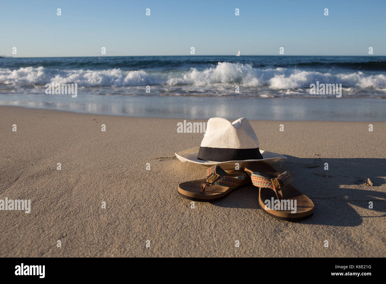 L'Europa, Spagna, Balearen, Mallorca, Cala Mesquida - Summerfeeling - un cappello bianco e Flip Flop sono giacenti da sole in spiaggia Foto Stock
