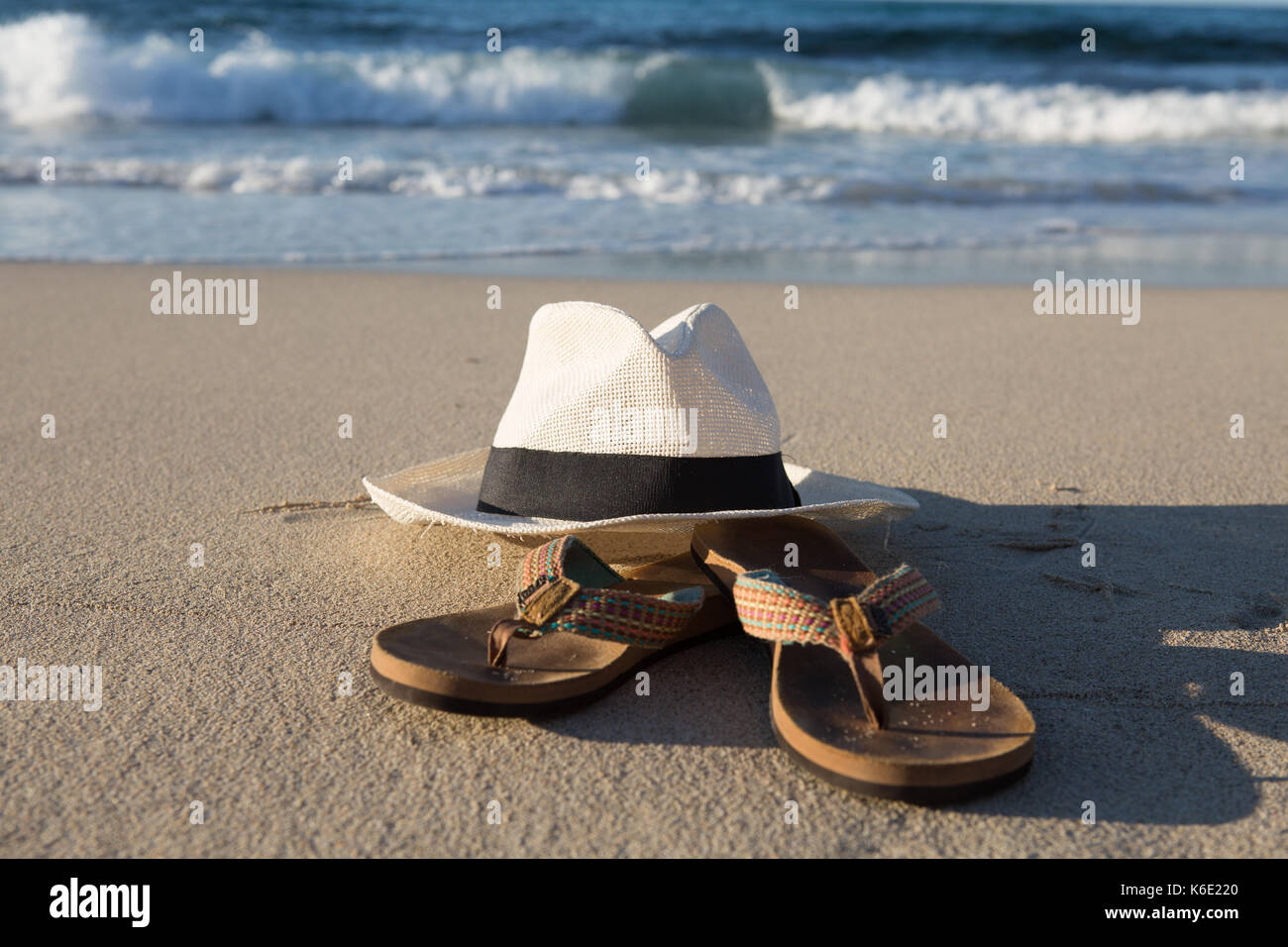 L'Europa, Spagna, Balearen, Mallorca, Cala Mesquida - Summerfeeling - un cappello bianco e Flip Flop sono giacenti da sole in spiaggia Foto Stock