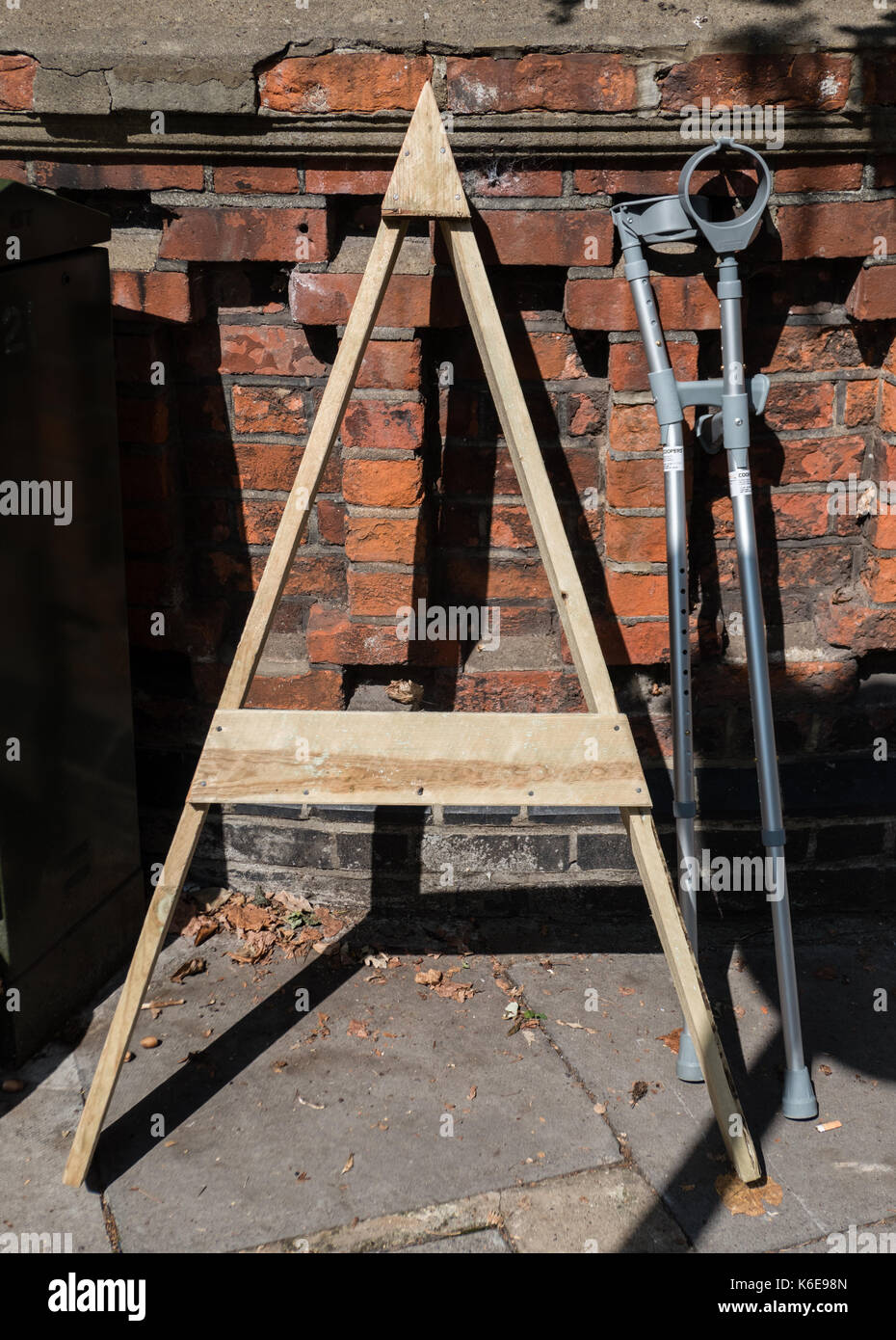 Un modello di legno e due stampelle abbandonati Foto Stock