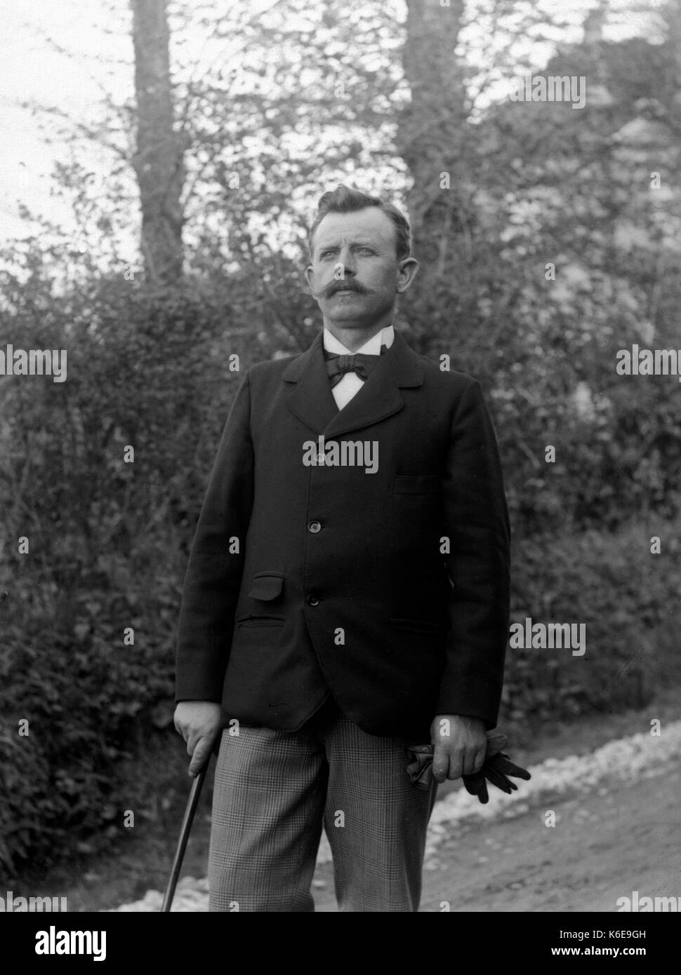 AJAXNETPHOTO. 1891-1910 (circa). SAINT-LO regione Normandia.FRANCIA. - Elegantemente vestito uomo con il filtro Bow Tie, GIACCA BASTONE DA PASSEGGIO E GUANTI IN UN PAESAGGIO su una collina. fotografo:sconosciuto © IMMAGINE DIGITALE COPYRIGHT VINTAGE AJAX Picture Library Fonte: AJAX FOTO VINTAGE COLLEZIONE REF:AVL FRA 1890 B29X1218 Foto Stock