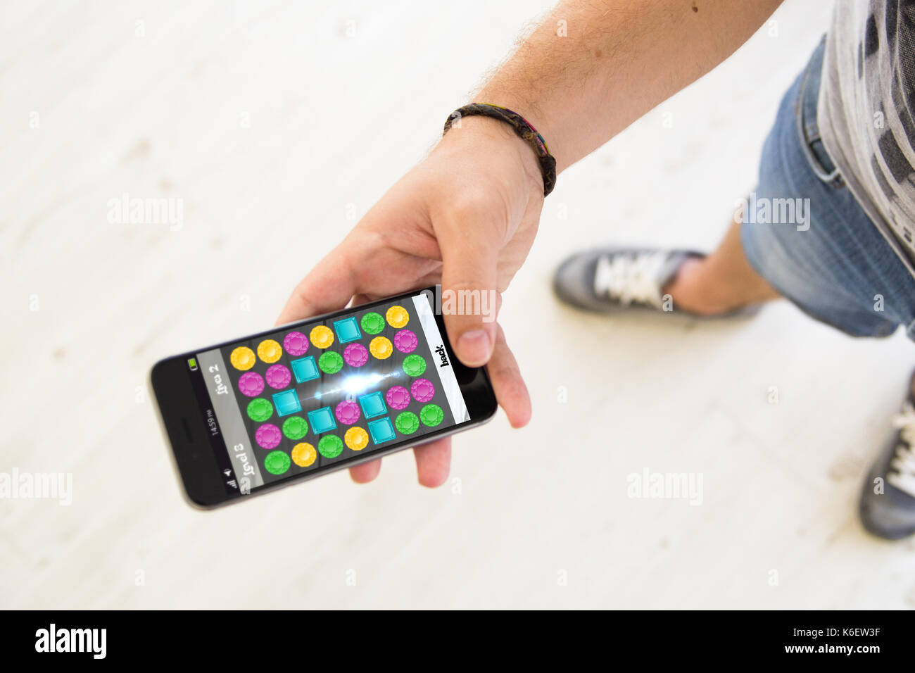 Primo piano della mano maschio utilizza lo smartphone per giocare a videogame Foto Stock