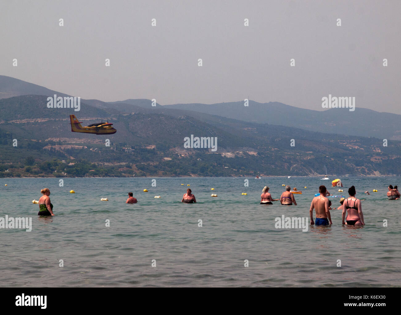 Sopra la spiaggia in alykanas un piano entra in per la raccolta di acqua per spegnere incendi nelle colline Foto Stock